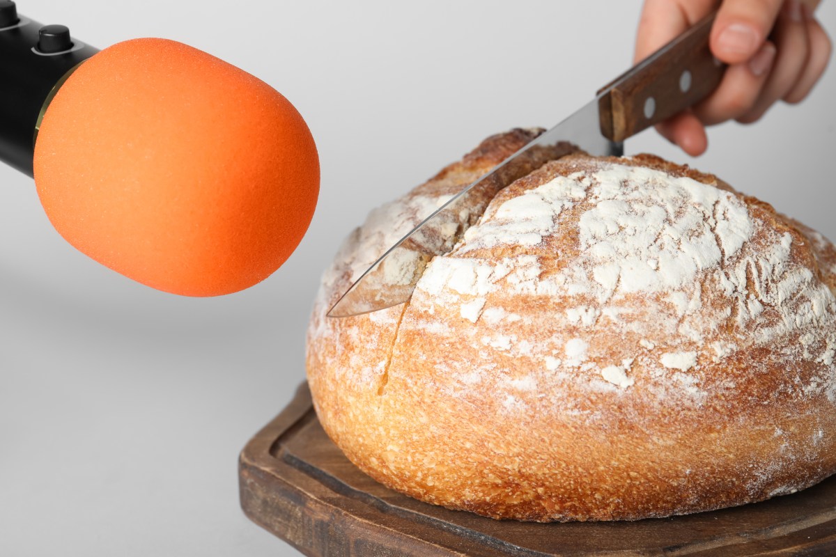 Brot wird neben Mikrofon aufgeschnitten