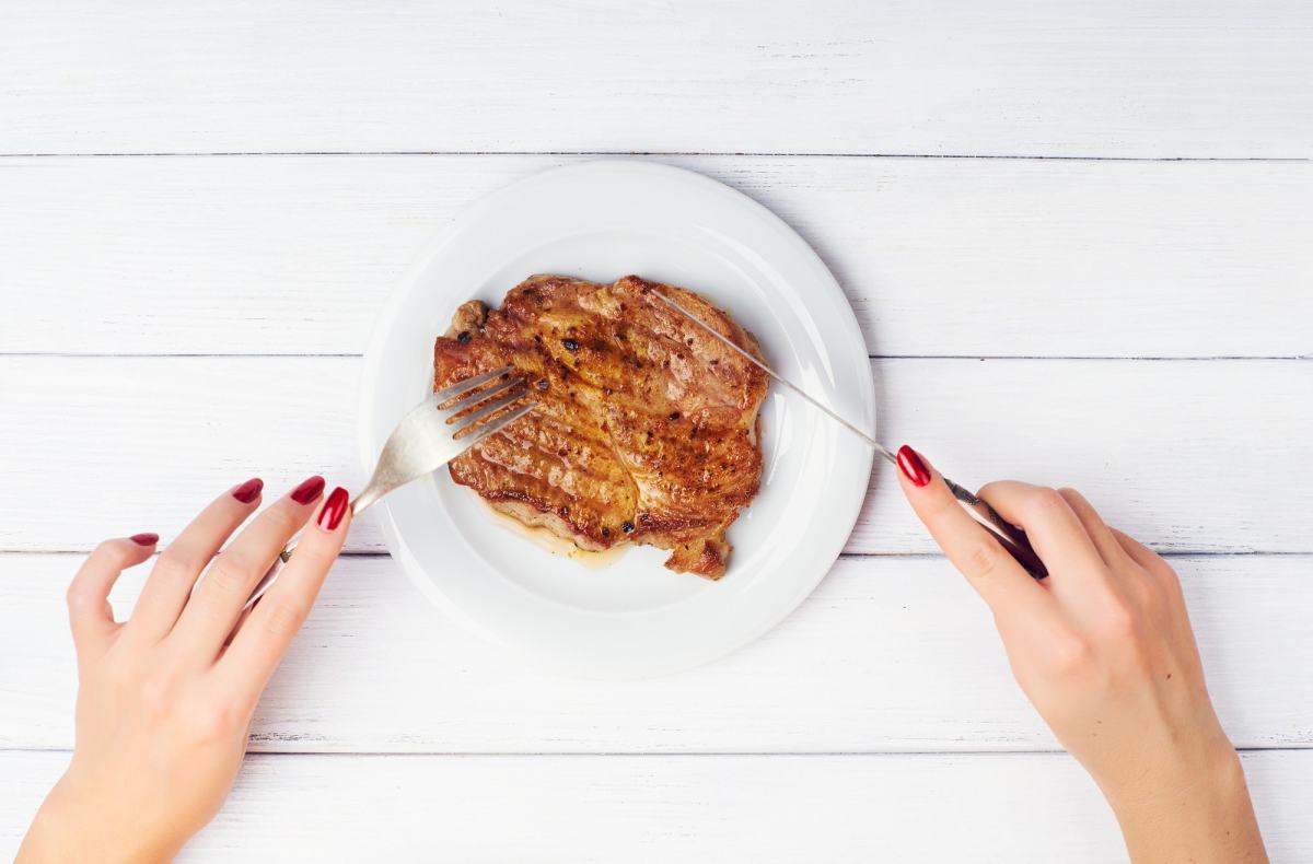 Frau, die Fleisch schneidet