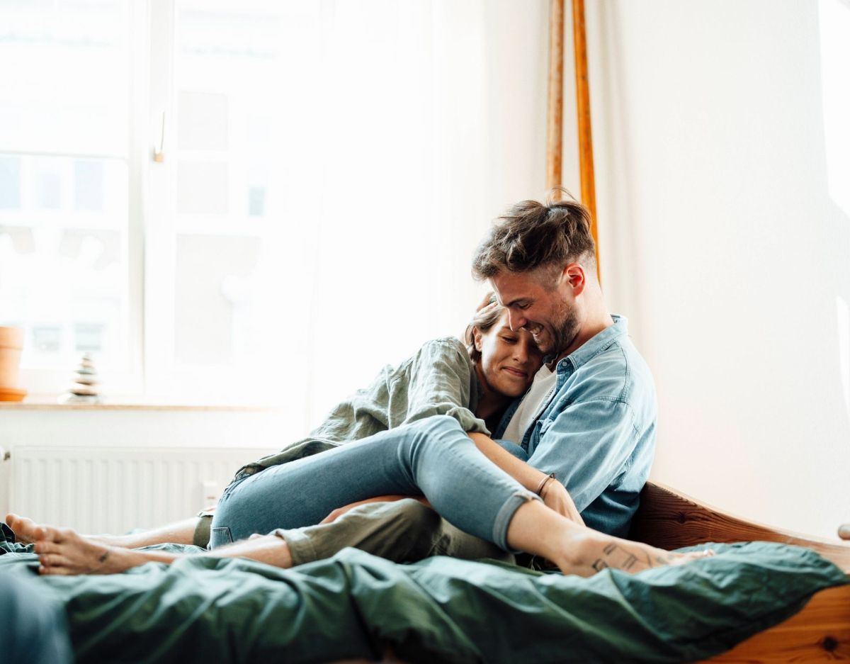 Frau und Mann kuscheln auf dem Bett