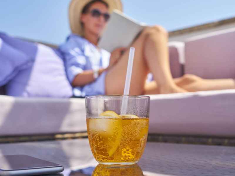 Frau sitzt am Pool mit einem Buch un Digital detox