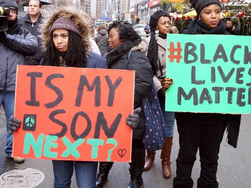 Zwei Frauen streiken mit #blacklivesmatter Schild in den Händen.