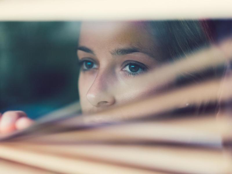 frau traurig aus dem Fenster schauen