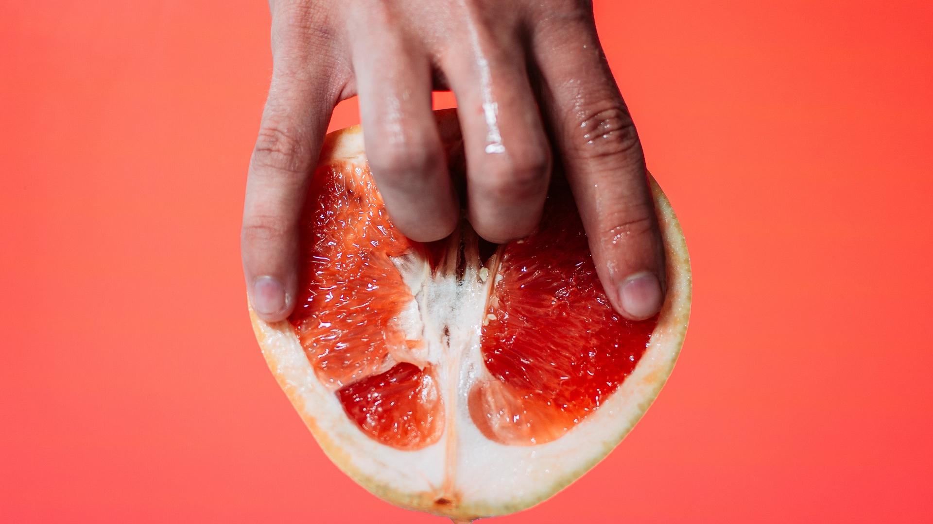 Zwei Finger dringen in Orange ein