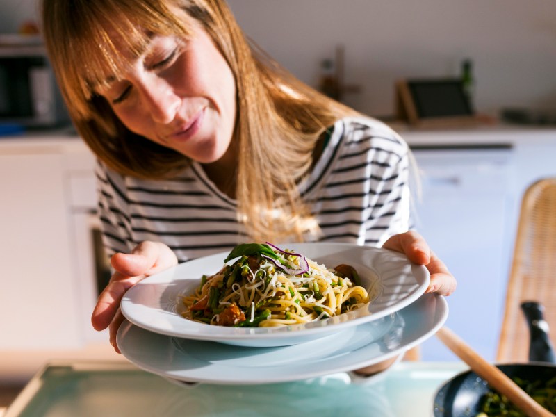 Frau mit sebstgekochtem Essen