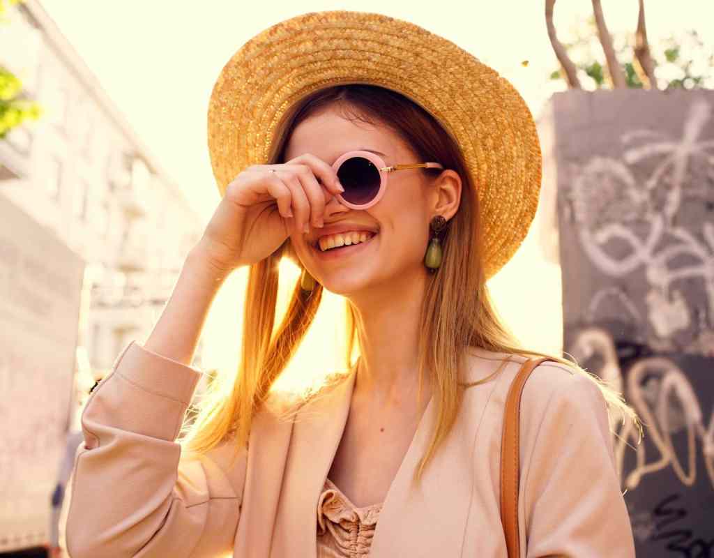 frau mit sonnenbrille und hut in der stadt sonne mineralische sonnencreme