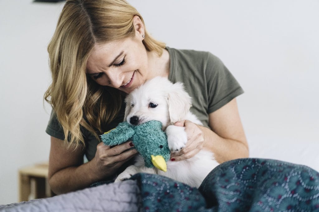 Lächelnde Frau mit Hund. Liebt mein Hund mich?