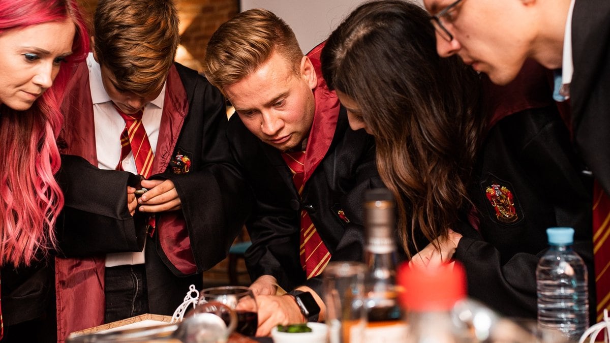 Leidenschaftliche Harry-Potter-Fans perfektionieren ihre Party mit ikonischen Gryffindor-Umhängen.. © Ekaterina Soldatenko/Shutterstock.com