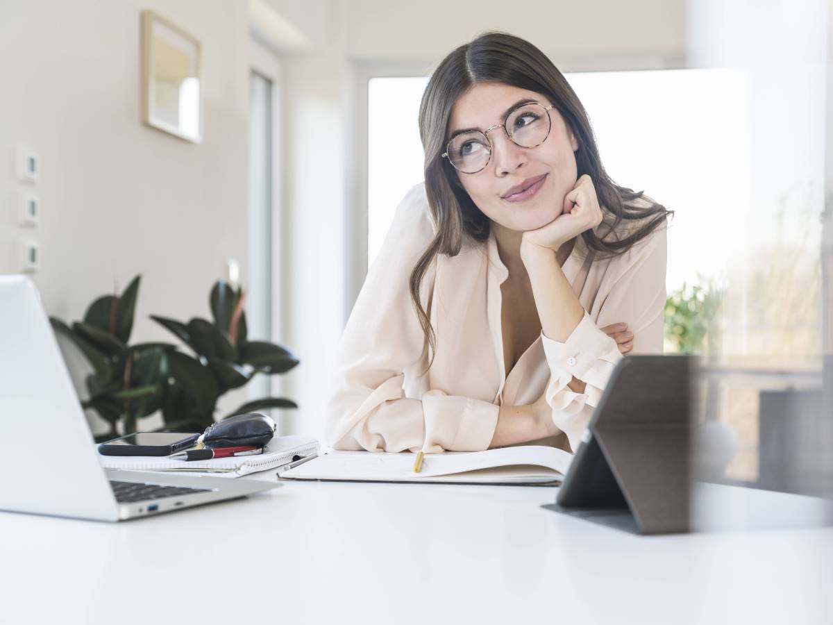 Frau sitzt lächelnd vor Computer