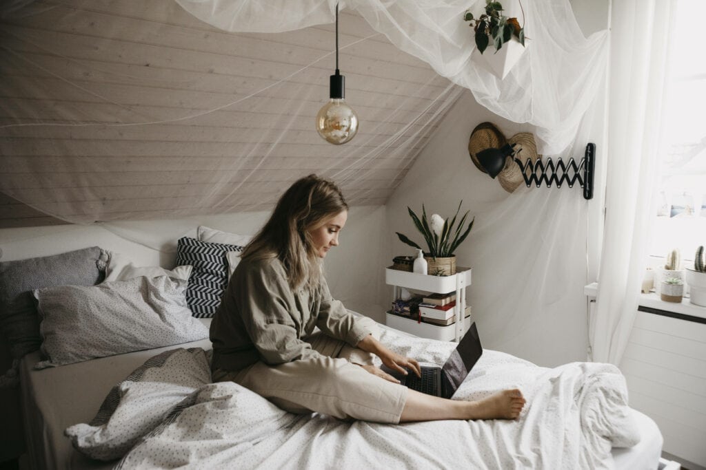 Frau mit laptop auf dem Bett