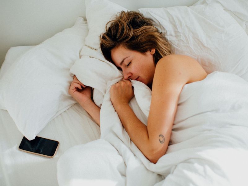 Frau im Bett mit Smartphone