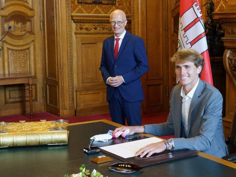 Alexander Zverev (vorne) trägt sich in das Goldene Buch der Stadt Hamburg ein. © imago images/Chris Emil Janßen