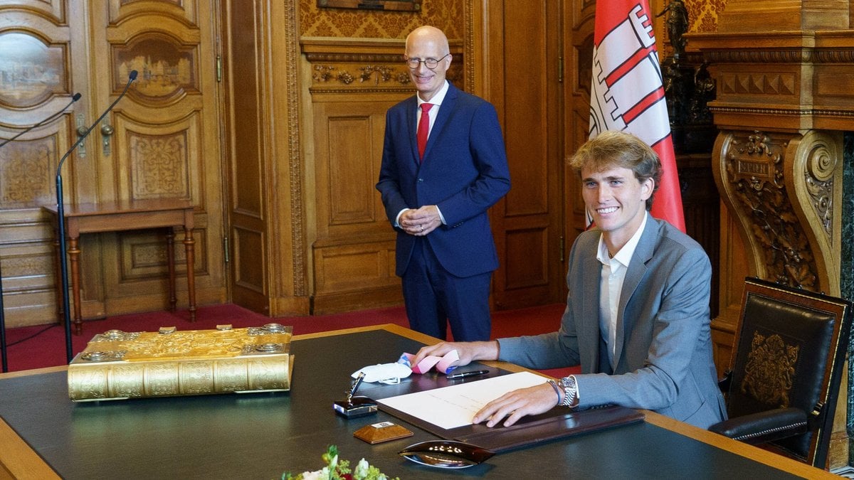 Alexander Zverev (vorne) trägt sich in das Goldene Buch der Stadt Hamburg ein. © imago images/Chris Emil Janßen