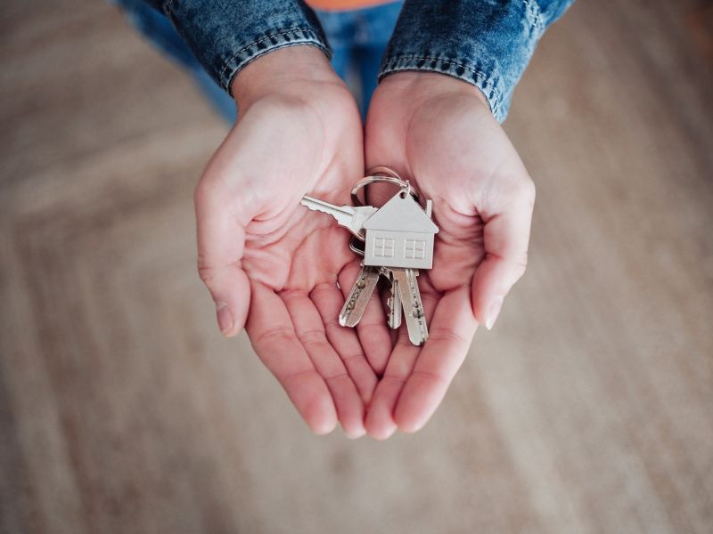 Hände mit Wohnungsschlüssel in der Hand