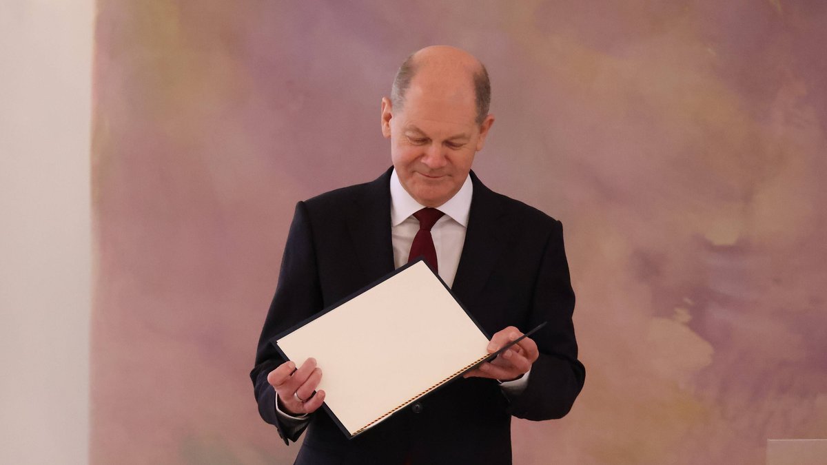 Bundeskanzler Olaf Scholz mit seiner Ernennungsurkunde.. © imago/Frank Ossenbrink