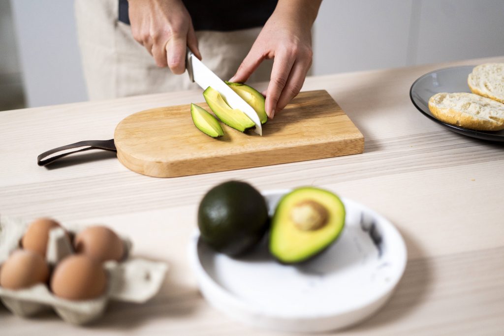 Frau schneidet Avocado