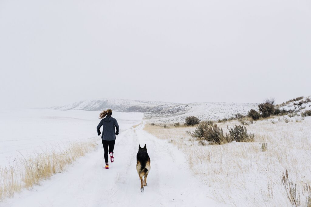 Frau Joggn mit Hund Winter Schnee