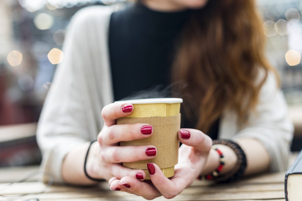 Hände mit Kaffeebecher