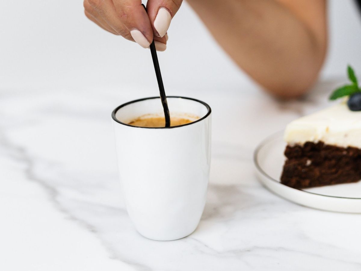 Hand rührt im Kaffee