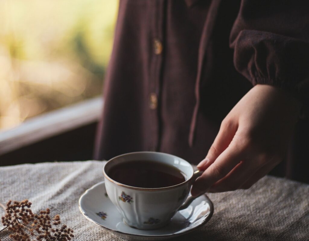 Hand mit Teetasse