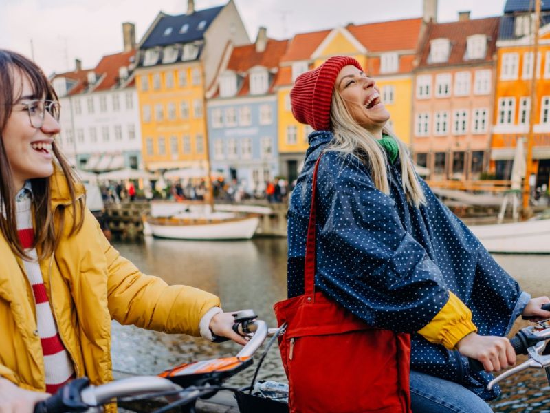 Geheimtipps für Kopenhagen zwei Frauen fahren Fahrrad Nyhavn