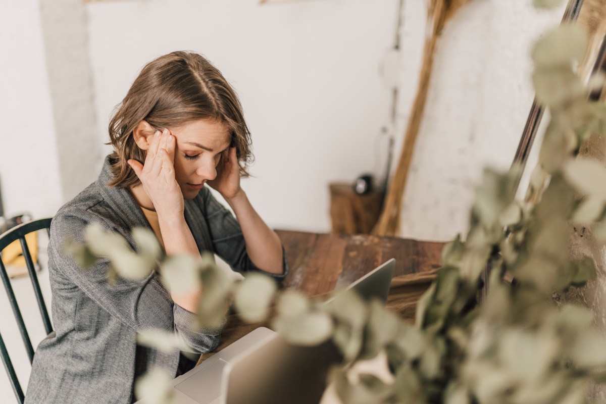 Eine Frau mit Konzentrationsproblemen vor dem Laptop.