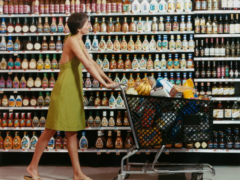 Frau mit Einkaufswagen im Supermarkt