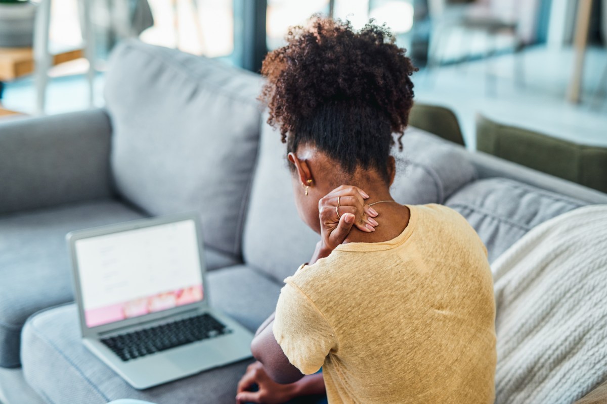 Frau mit rundem Rücken vor Laptop