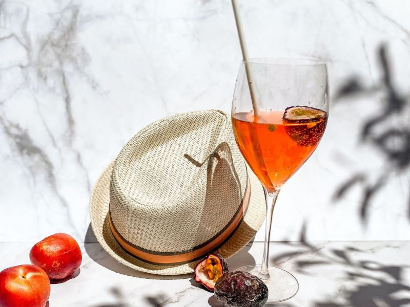 Aperol Spritz neben einem Hut