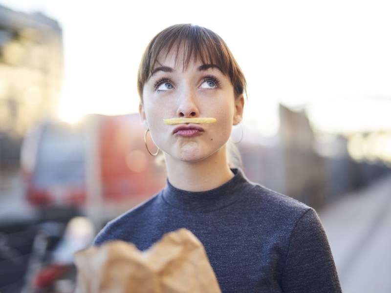 Frau mit Pommes unter der Nase