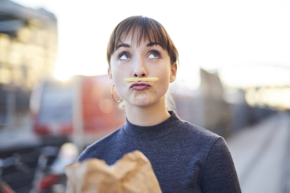 Frau mit Pommes unter der Nase