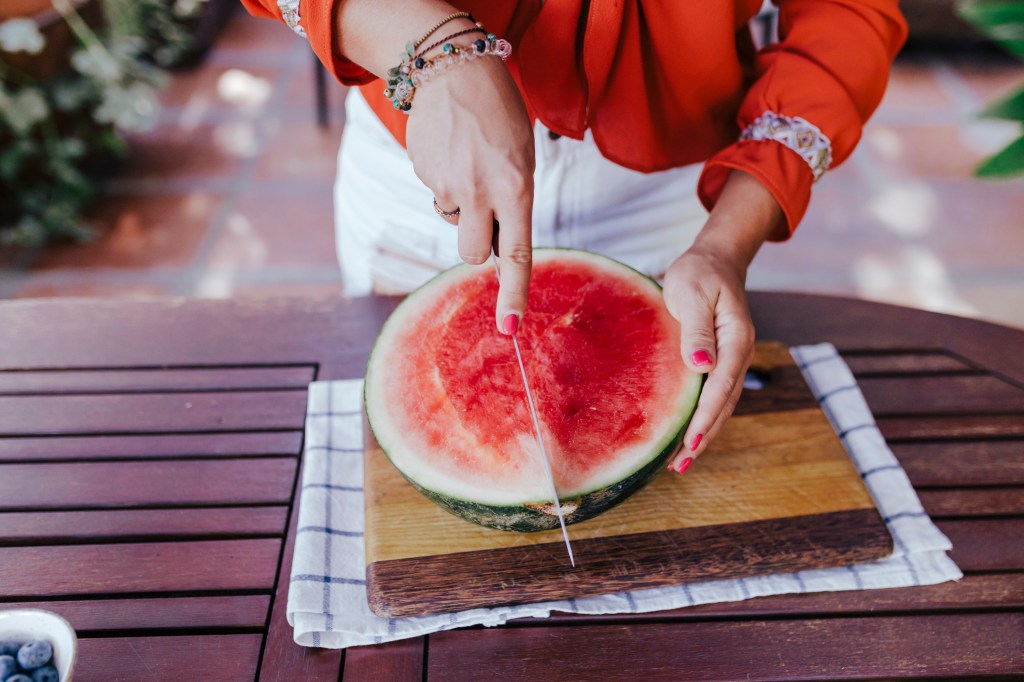 Frau schneidet Melone