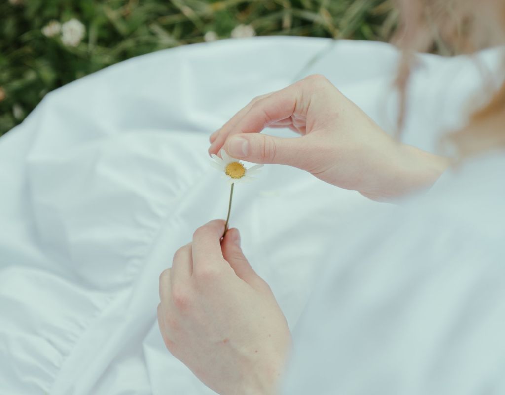 Frau hält Blume in der Hand