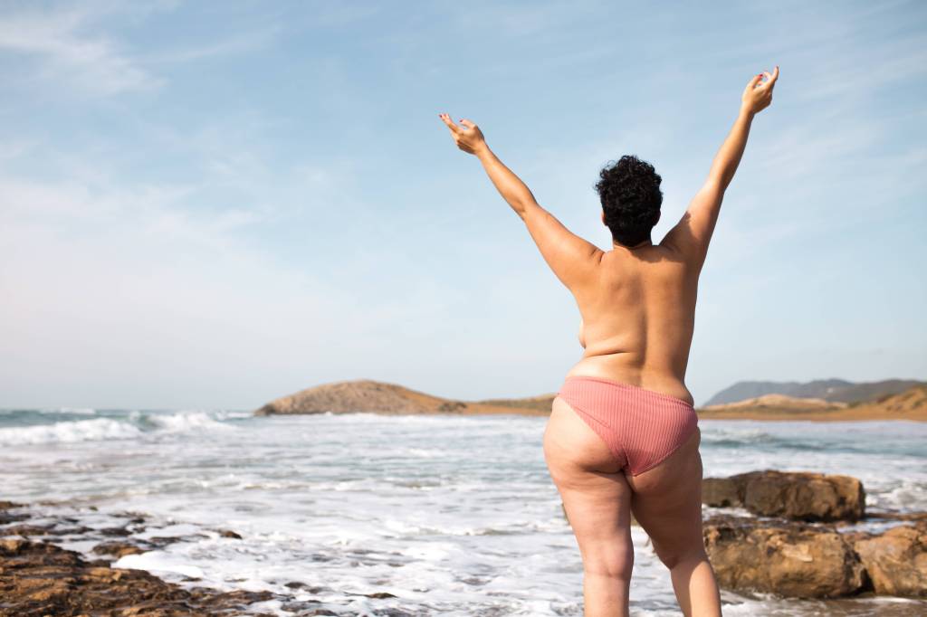 Frau oberkörperfrei am Strand