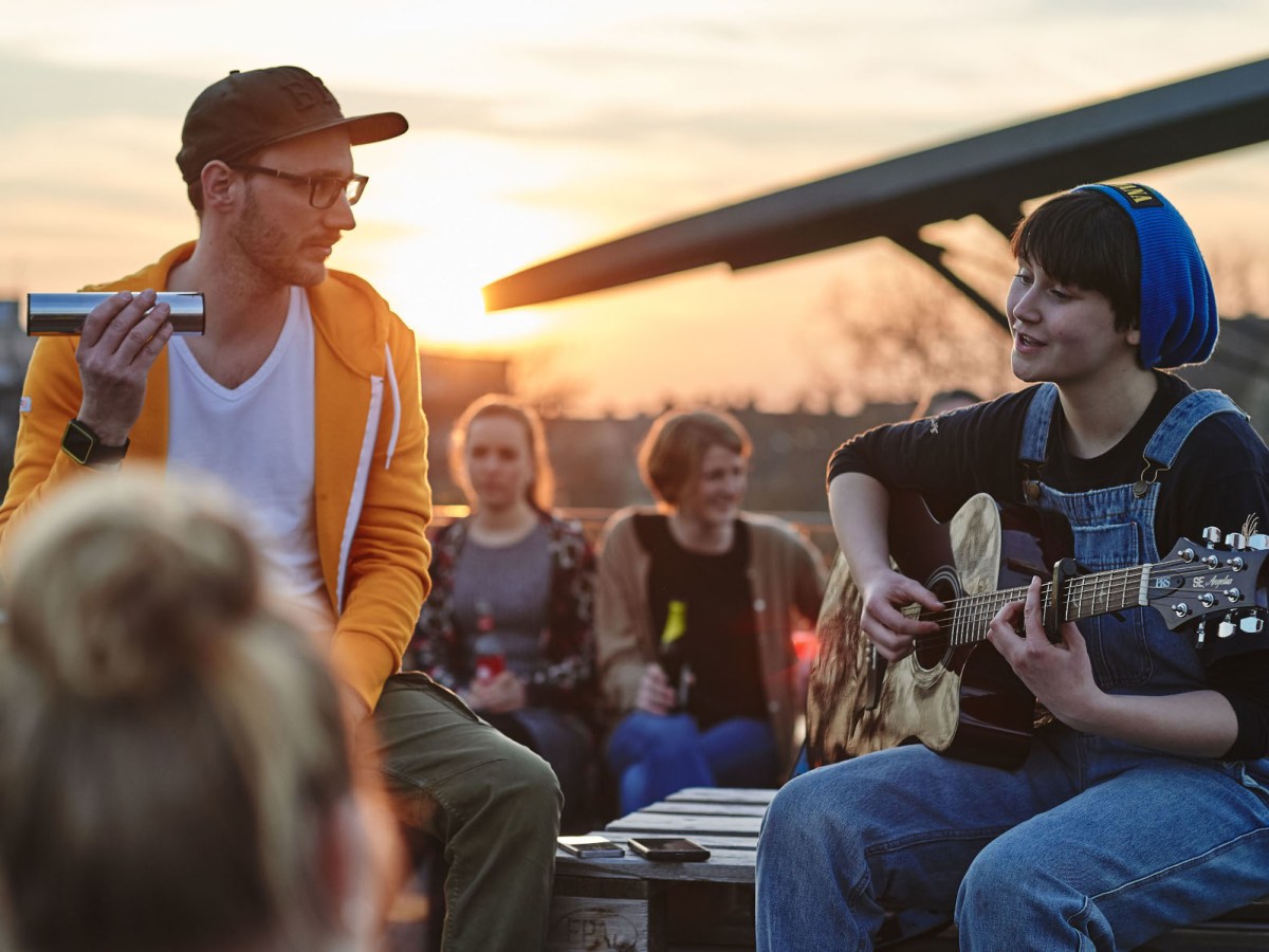 Eine Musikerin spielt Gitarre. Für ihre Buchhaltung nutzt sie lexoffice.