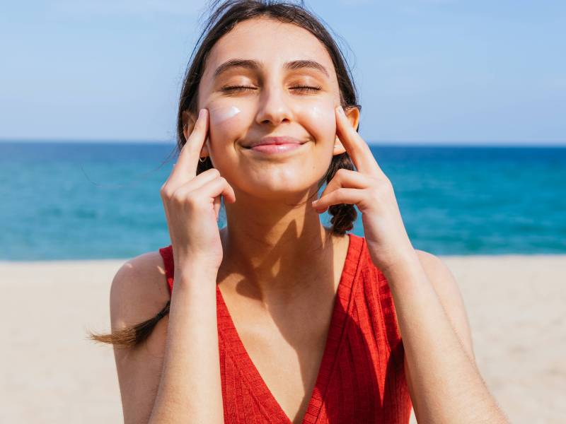 Frau mit Sonnencreme im Gesicht