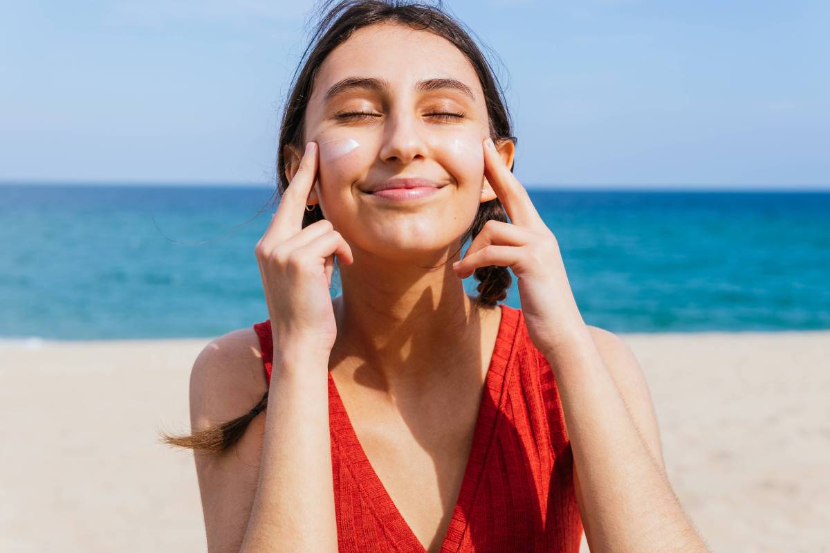 Frau mit Sonnencreme im Gesicht