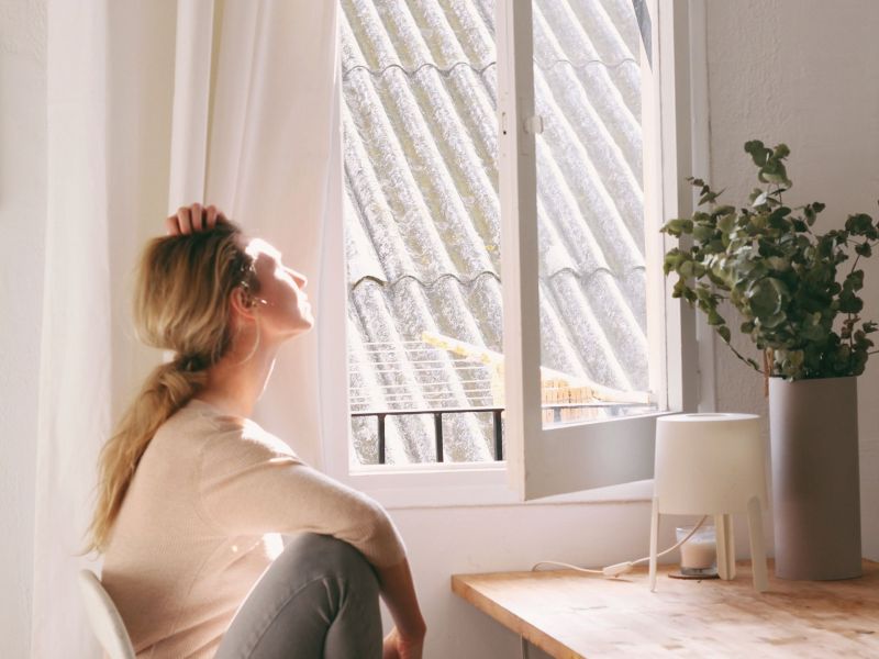 Frau am geöffneten Fenster