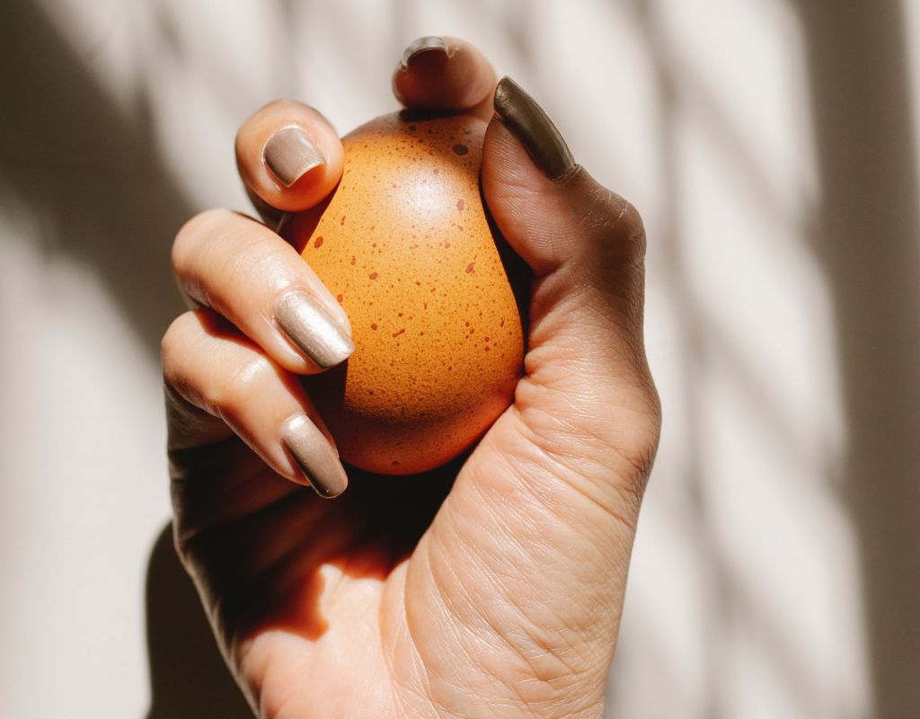 Frau h&auml;lt Ei in der Hand