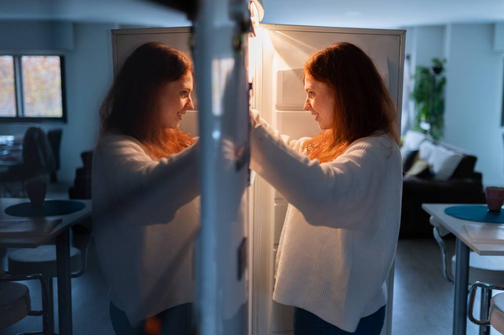 Frau sucht im Kühlschrank