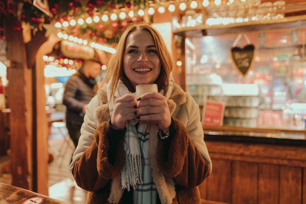 Frau mit Glühwein auf dem Weihnachtsmarkt