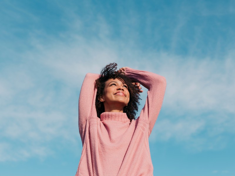 Junge Frau vor blauem Himmel