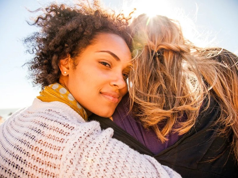 Frauen umarmen sich in der Öffentlichkeit.