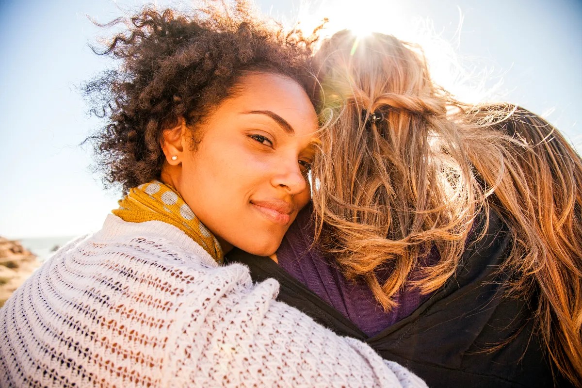 Frauen umarmen sich in der Öffentlichkeit.