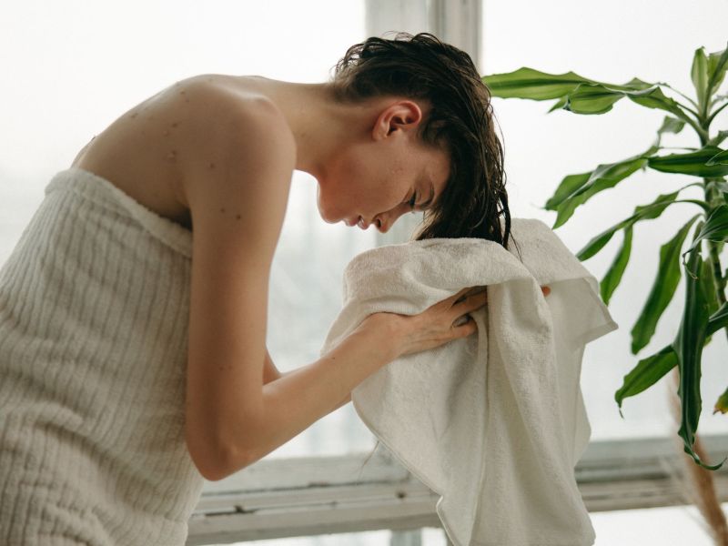 Frau trocknet sich mit Handtuch die Haare