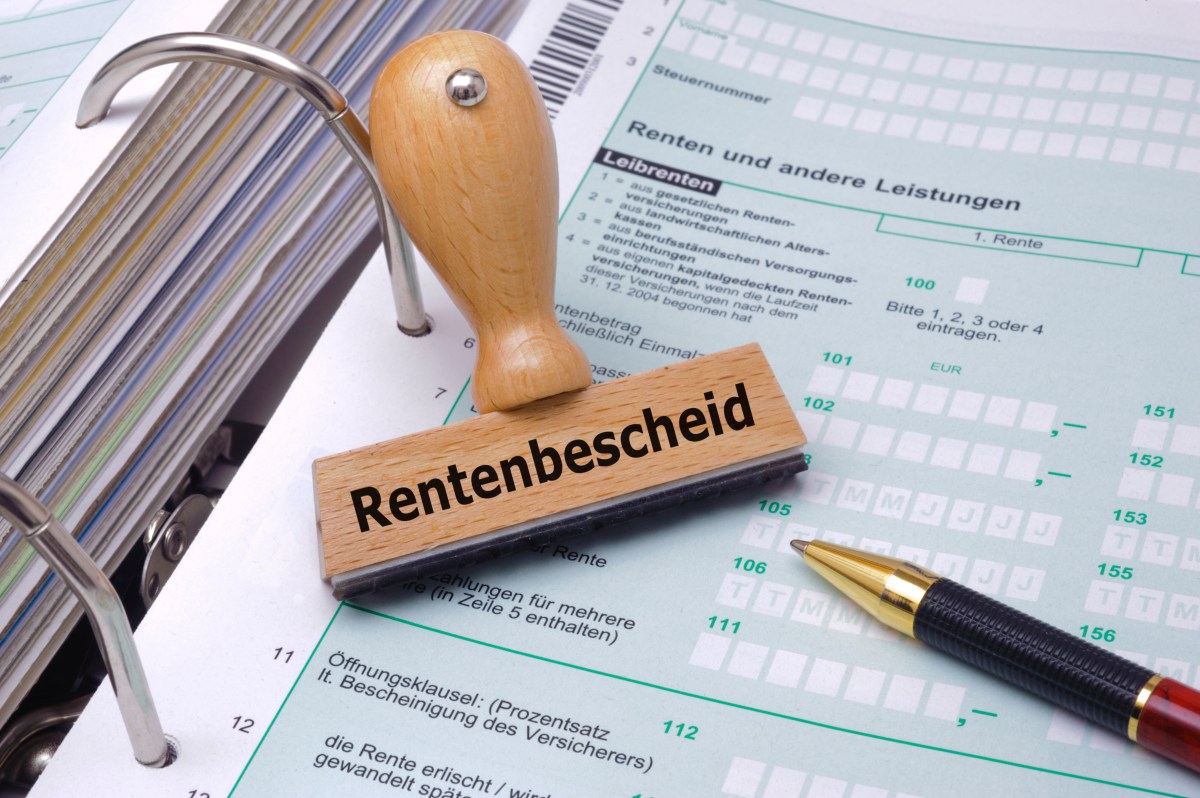 Ein Stempel mit dem Aufdruck "Rentenbescheid" liegt auf einem Rentenantrag.