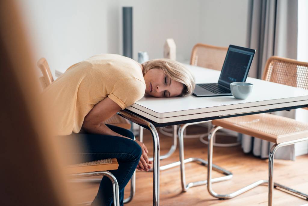 Frau schläft mit Kopf auf dem Tisch