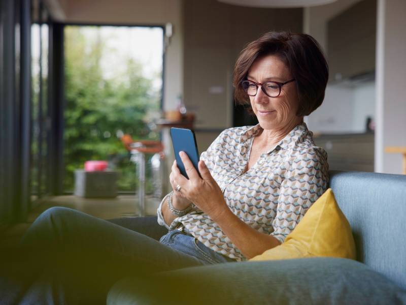 Frau hält Telefon in der Hand.