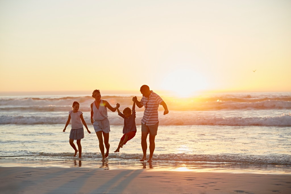 Familie bei Sonnenuntergang am Strand.