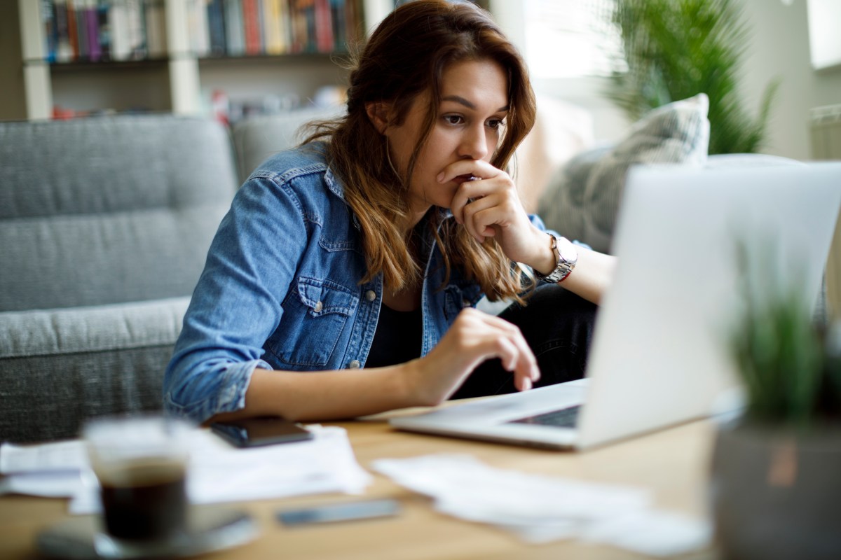 Frau sitzt konzentriert vor dem Laptop.