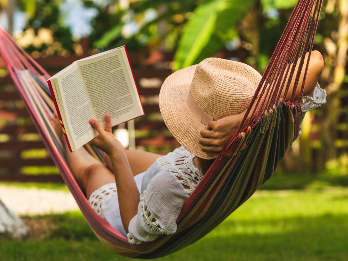 Frau liest ein Buch in einer Hängematte